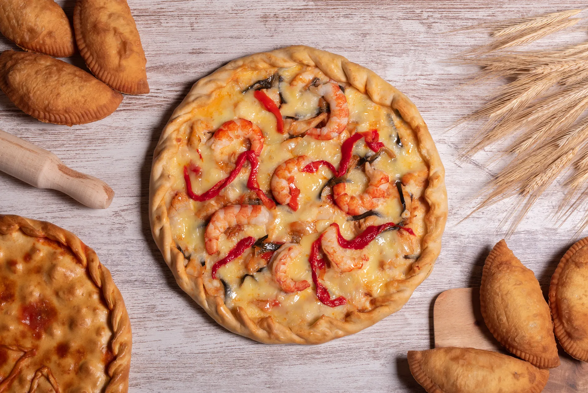 Mesa con empanada gallega, empanadillas y una patela