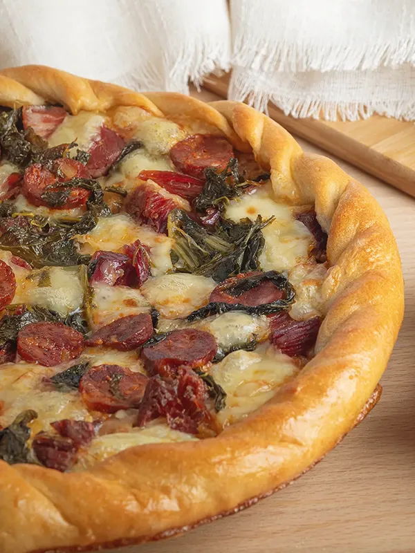 Primer plano de patela de chorizo, grelos y queso