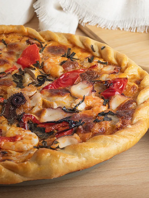 Primer plano de Patela de pulpo con gambas, pimientos y queso